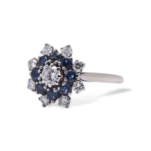 Bague marguerite en platine avec diamant et saphirs bleu-gris.